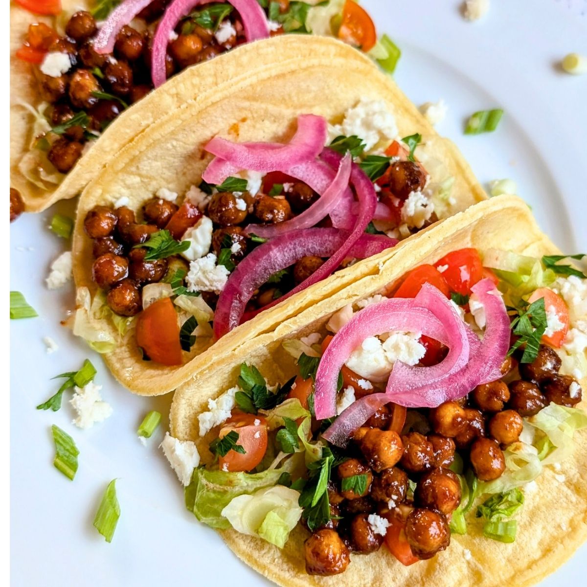 garbanzo bean tacos in a corn tortilla with pickled onions and lettuce.