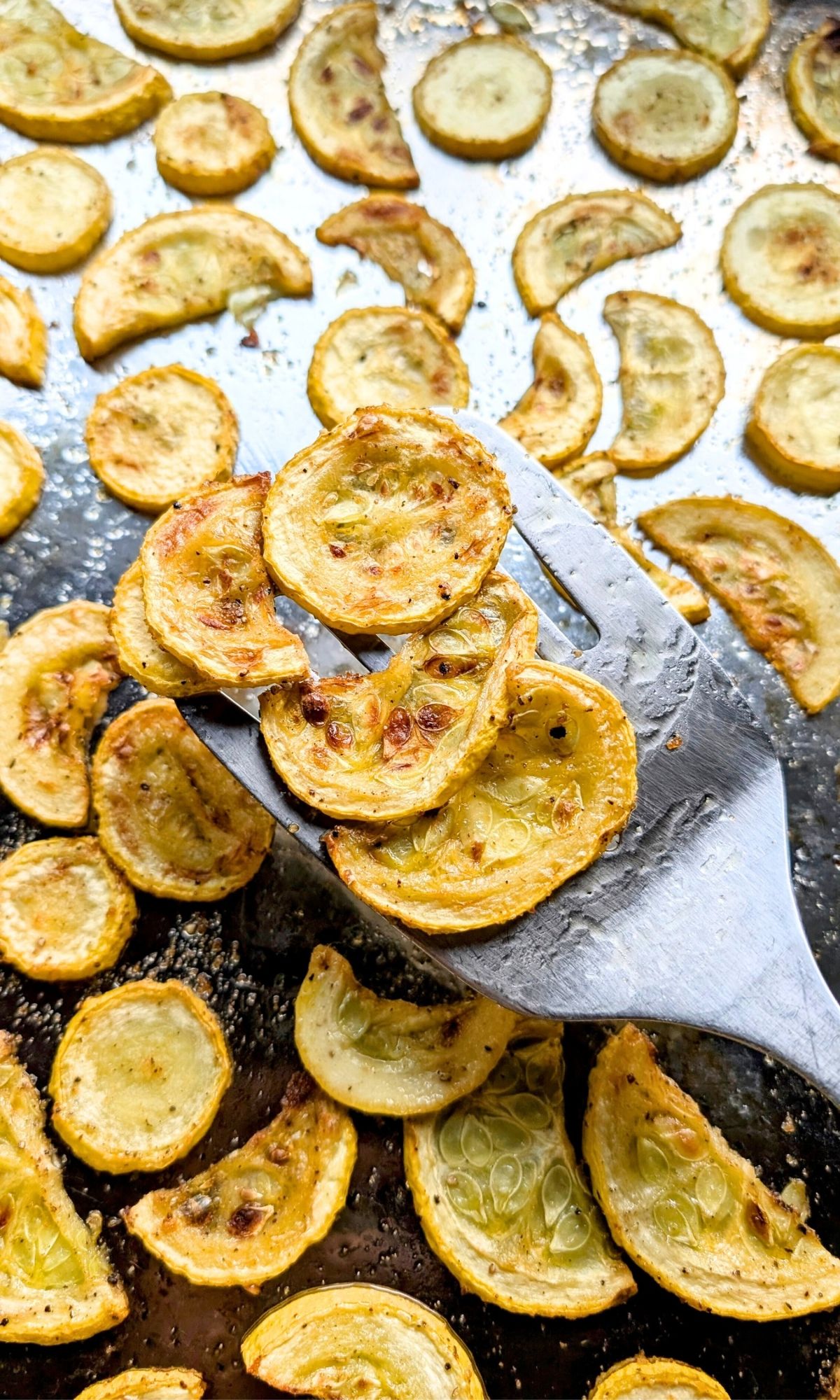 a spatula tossing roasted crookneck squash for a late summer or early fall side dish recipe.