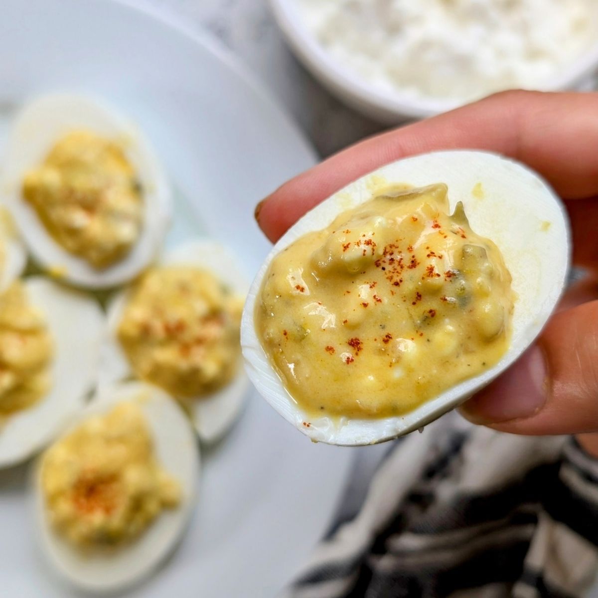 a hardboiled deviled egg filled with cottage cheese and topped with paprika for a high protein appetizer.