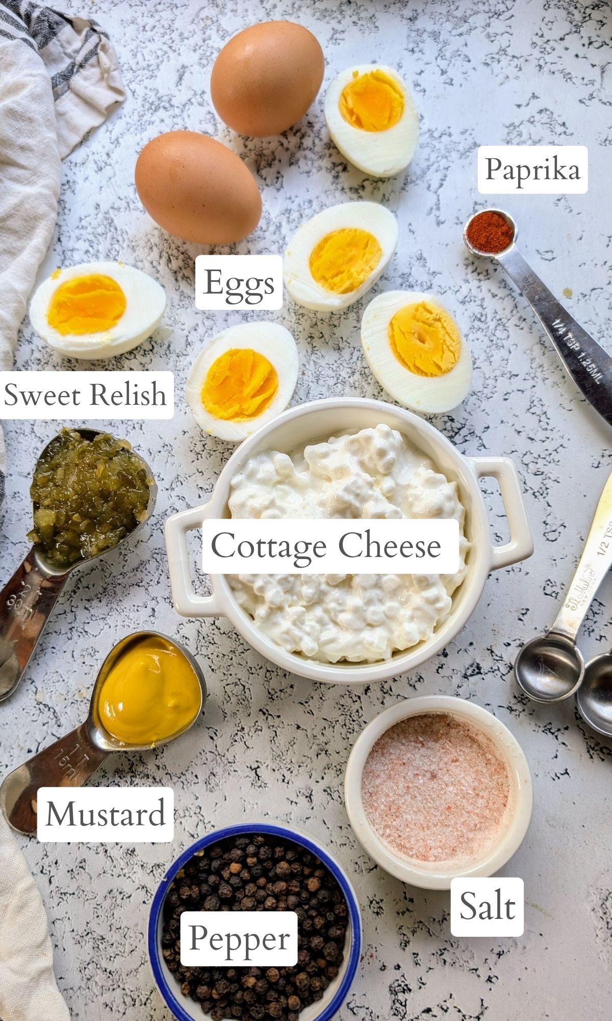 ingredients for deviled eggs with cottage cheese like hardboiled eggs, sweet relish, mustard, and paprika as a garnish.