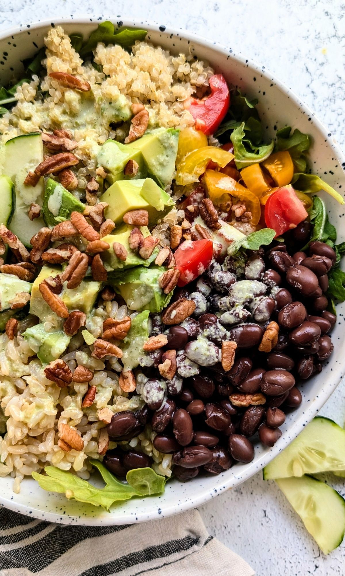 black bean quinoa southwest bowls with brown rice and a spicy jalapeno lime dressing with vegetables.