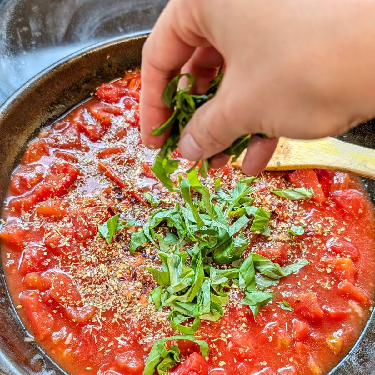 olive oil garlic and tomatoes in a cast iron skillet to make pasta alla Siciliana al forno