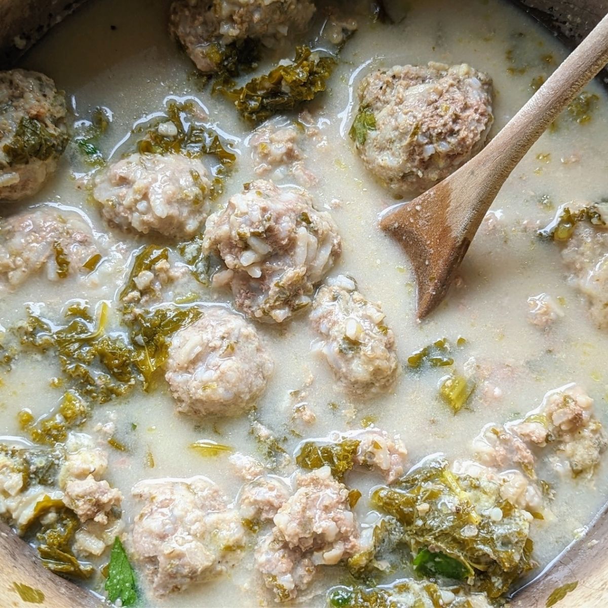 simmering Greek meatball soup with escarole and avgolemono sauce