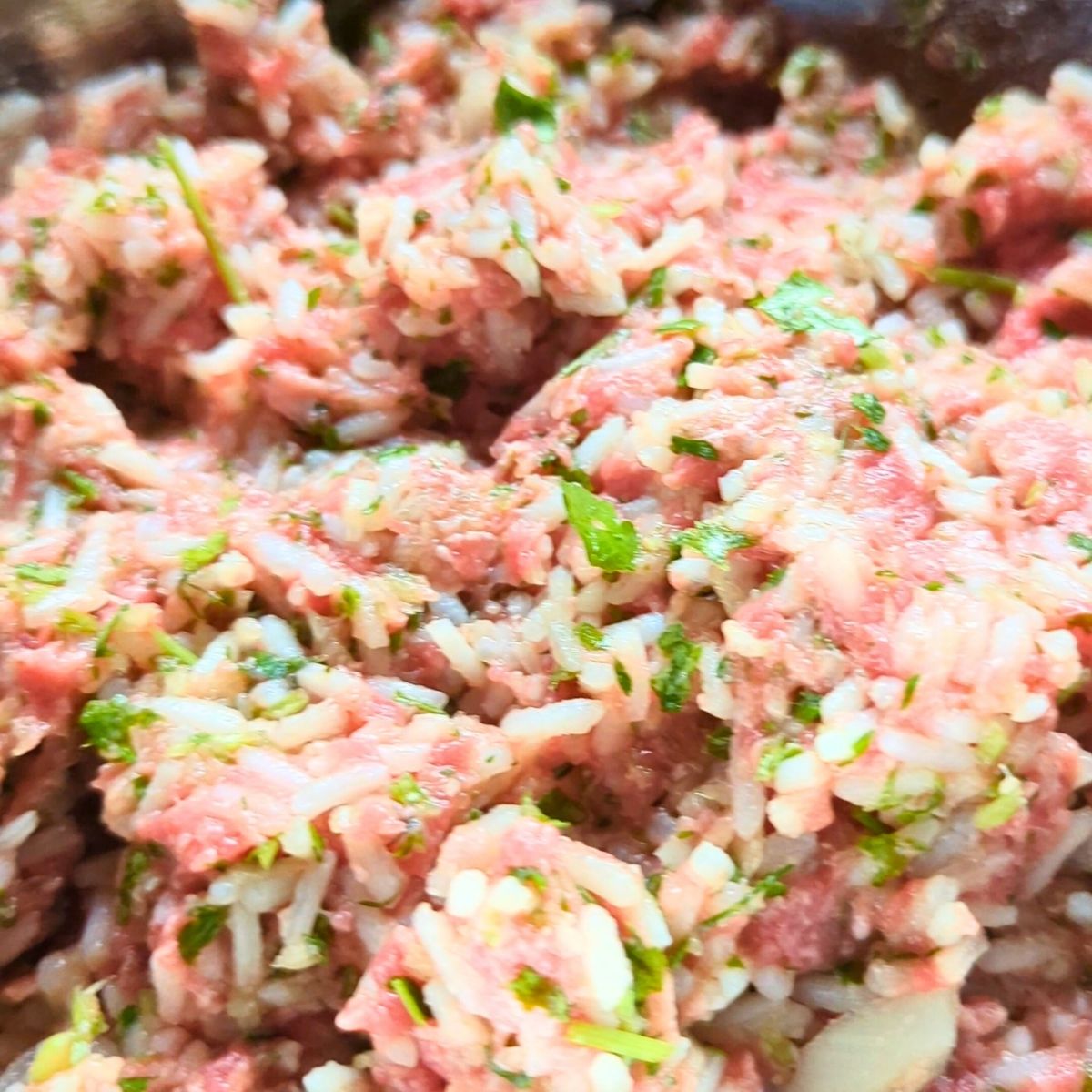 a bowl of ground beef, rice, herbs, and onions to make Greek meatballs soup youvarlakia recipe