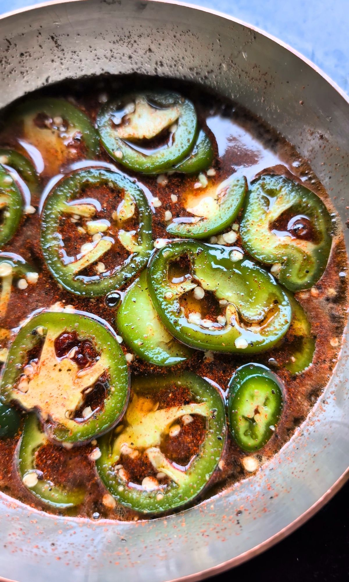 jalapeno peppers simmering in honey on a saucepan with smoky flavor.