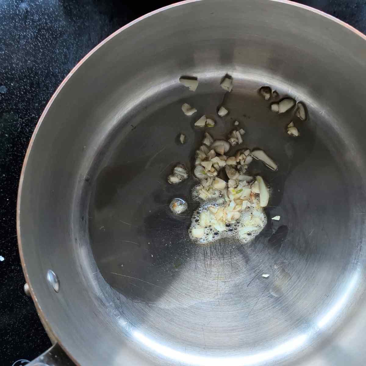 garlic sauteeing in sesame oil in a pot to make egg drop soup