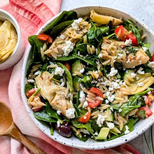 artichoke pasta salad with feta cheese tomatoes and spinach and orzo pasta noodles