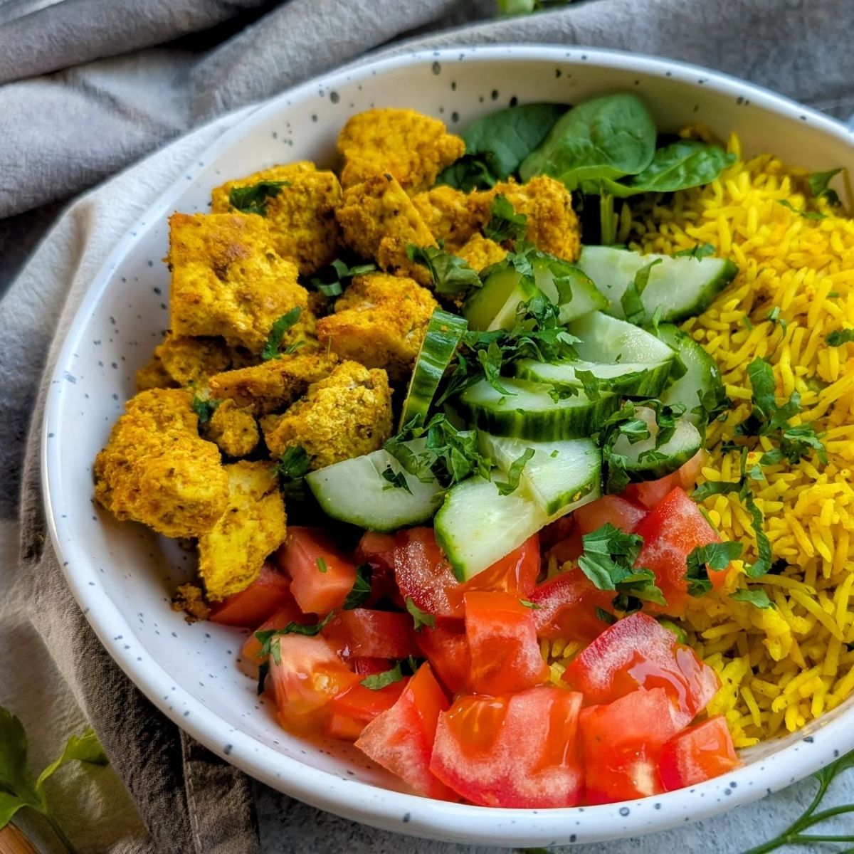 vegan tofu shawarma bowls with rice and cucumber and tomato and parsley.