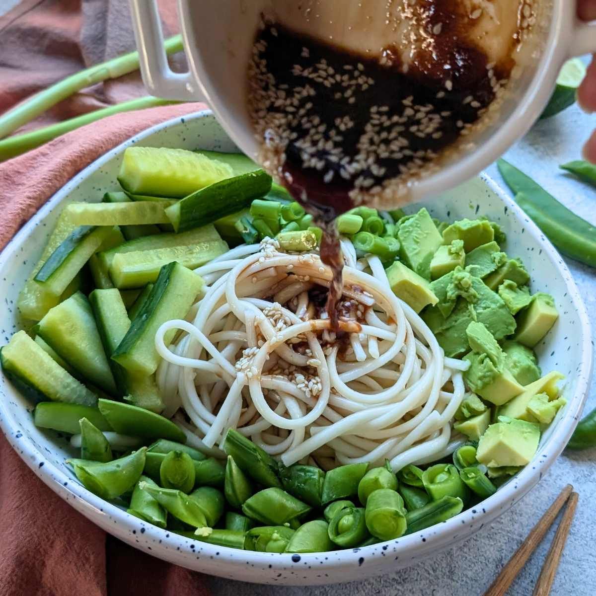 sesame lime udon noodle salad with dressing and fresh vegetables in a bowl for lunch.