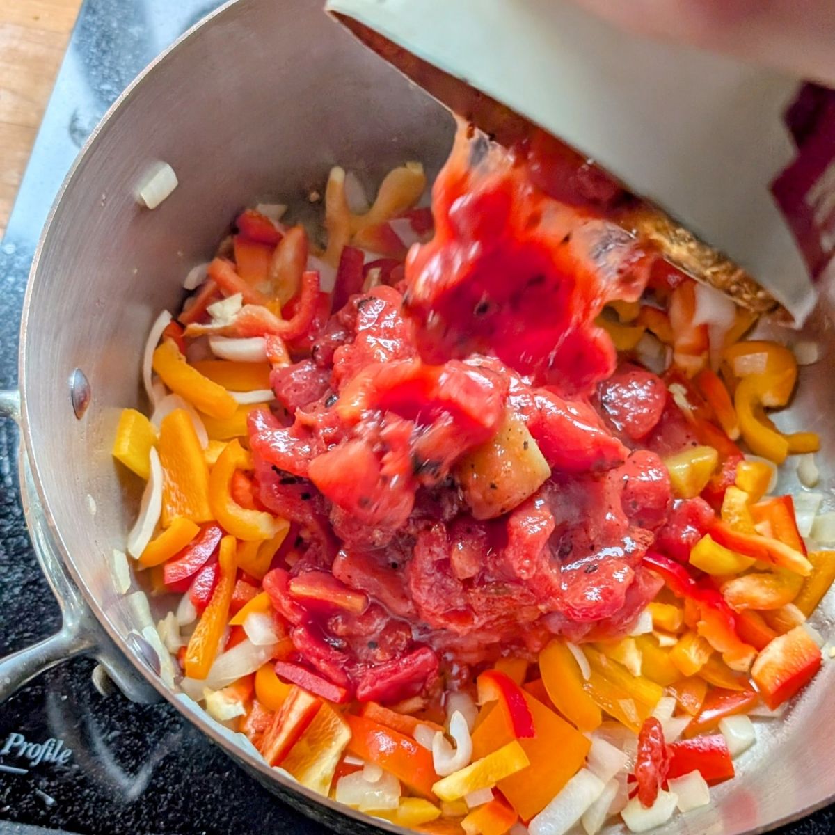 a pot of stuffed pepper soup with diced tomatoes added from a can