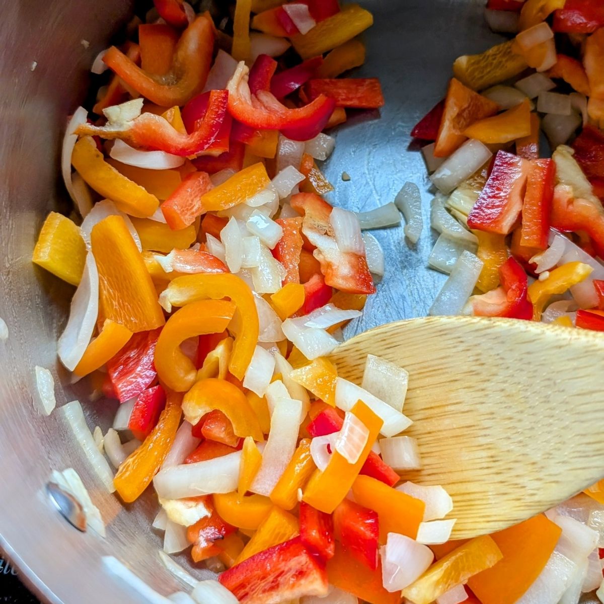 a soup pot with peppers, onions, and carrots sauteeing in olive oil to make pepper soup