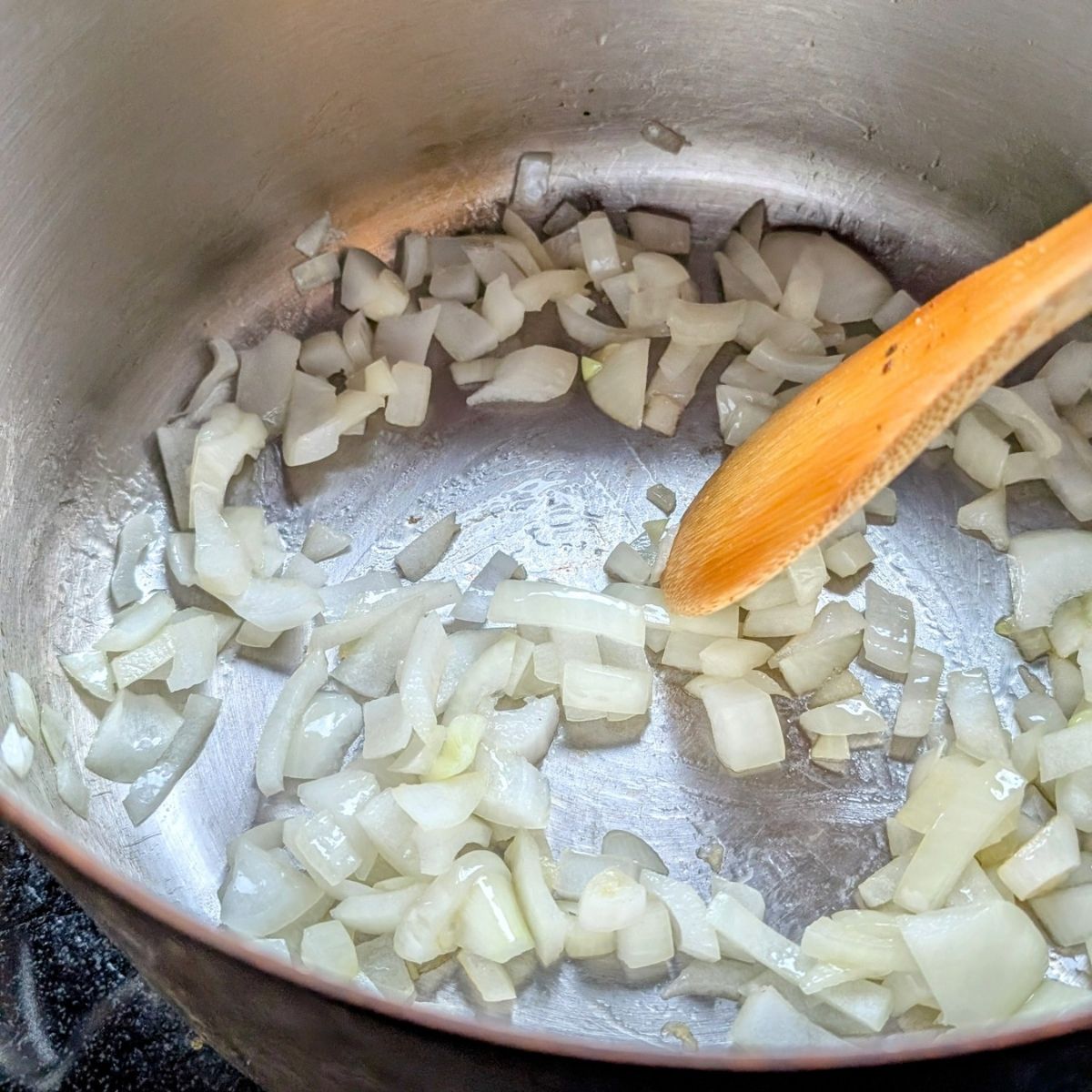 a pot with olive oil, garlic, and onions sauteed to make soup