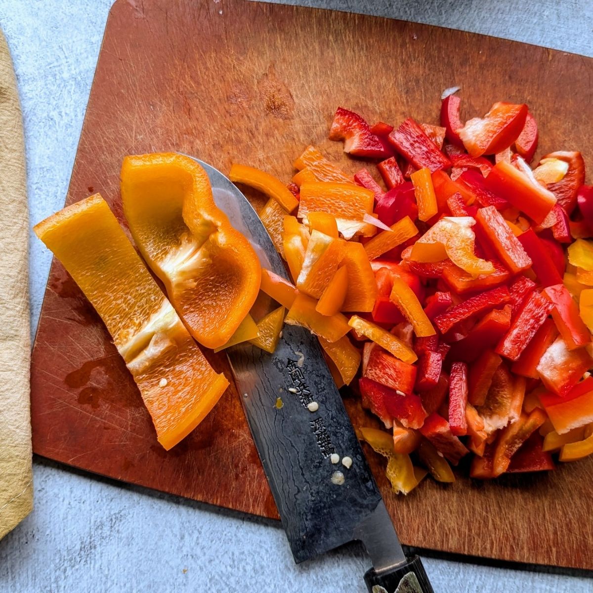 chopped bell peppers sliced to make stuffed pepper soup with a japanese knife.