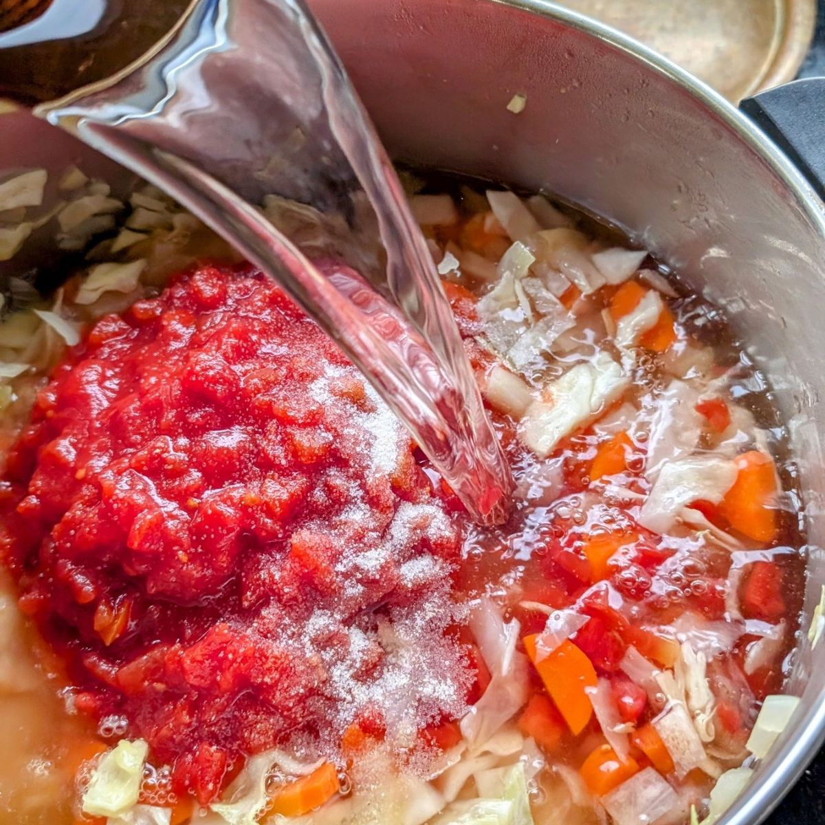 beans and water in a pot boiling to make bean cabbage soup