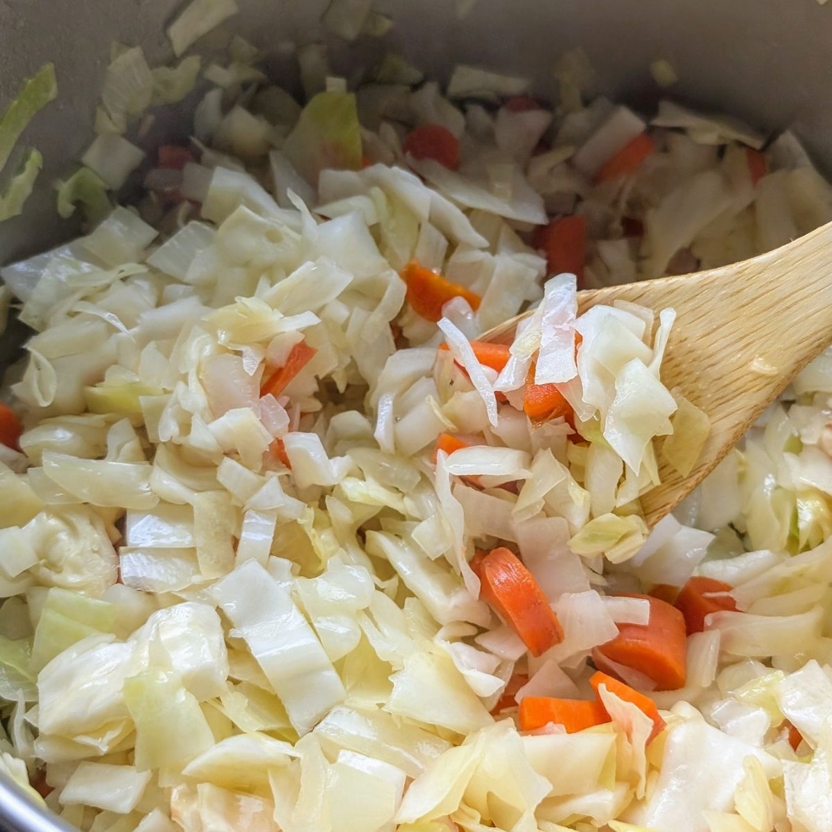 carrots, celery, and shredded cabbage in a pot to make soup with beans