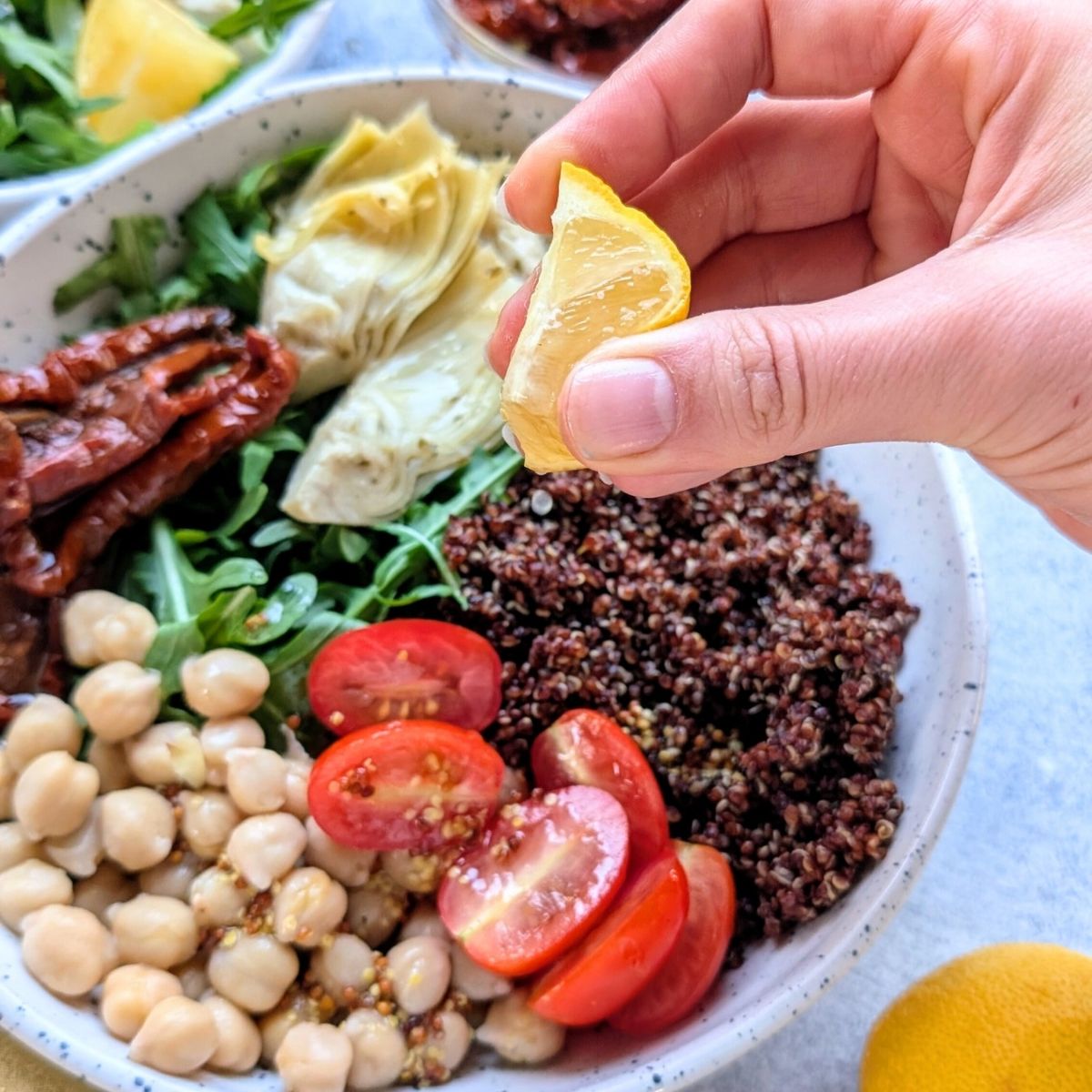 fresh lemon squeezed over a quinoa and arugula salad recipe