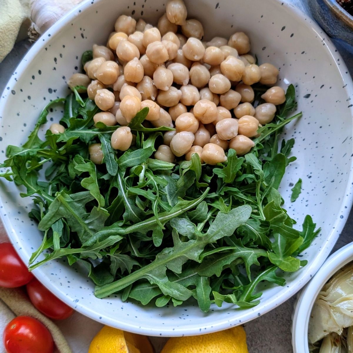 chickpeas and arugula in a bowl for mediterranean quinoa arugula salad