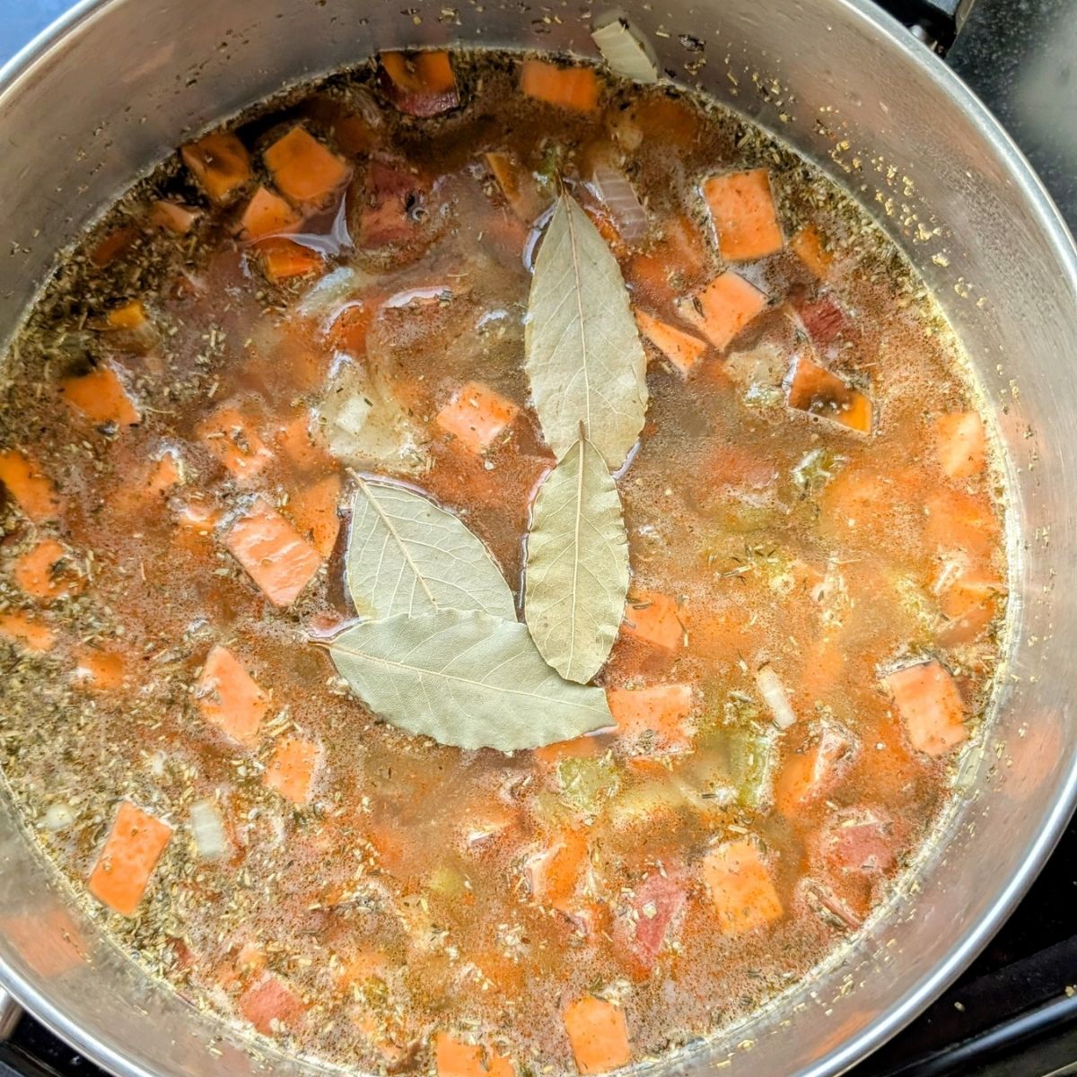 split pea soup with bay leaves and sweet potatoes in a pot for a vegan dinner recipe for winter