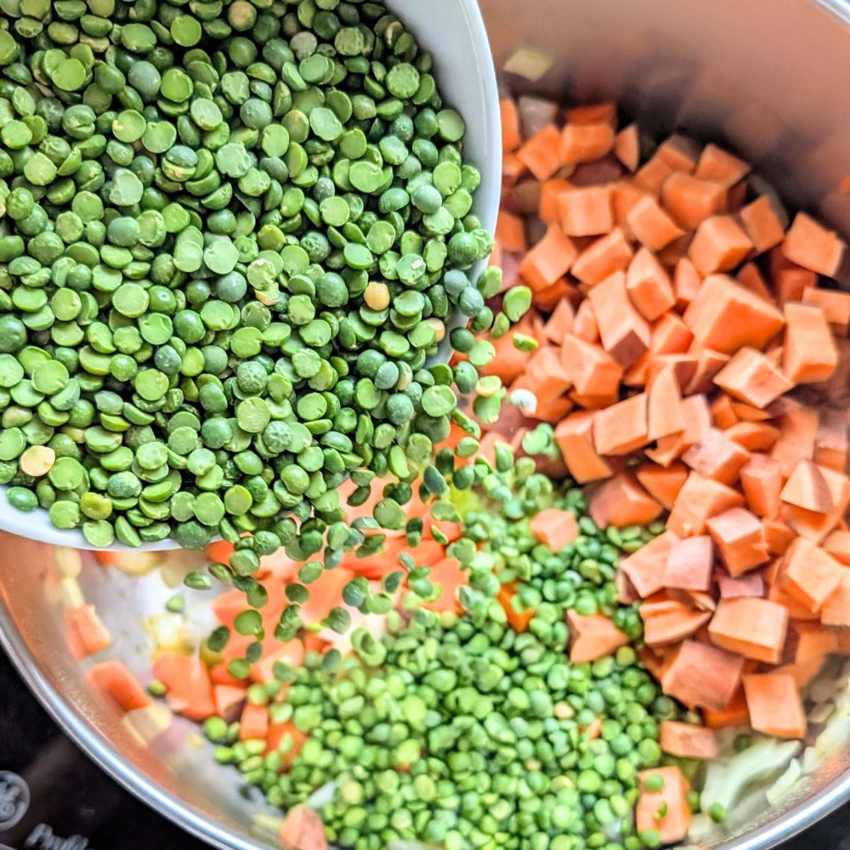 sweet potatoes and split peas added to a large pot with vegetables to make soup