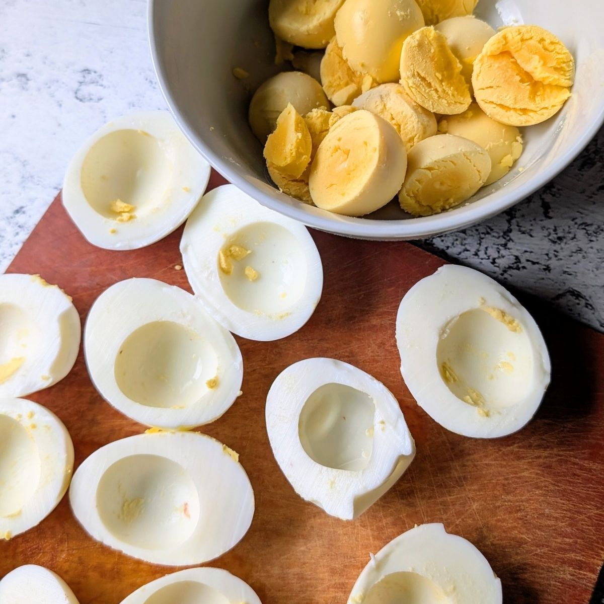 hardboiled eggs on a plate with yolks in a separate bowl