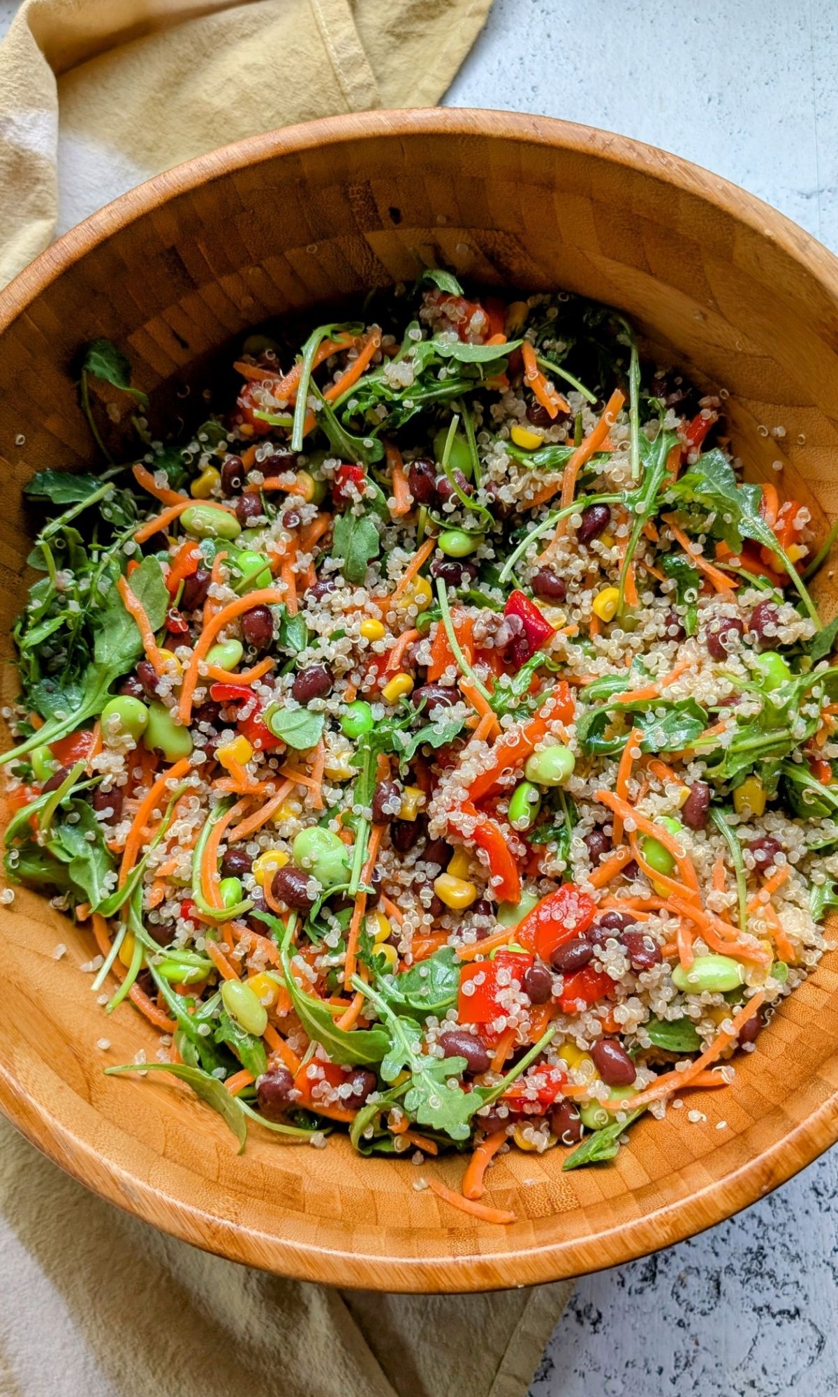 a bowl of black and and quinoa salad tossed with fresh vegetables and a lemon vinegar dressing