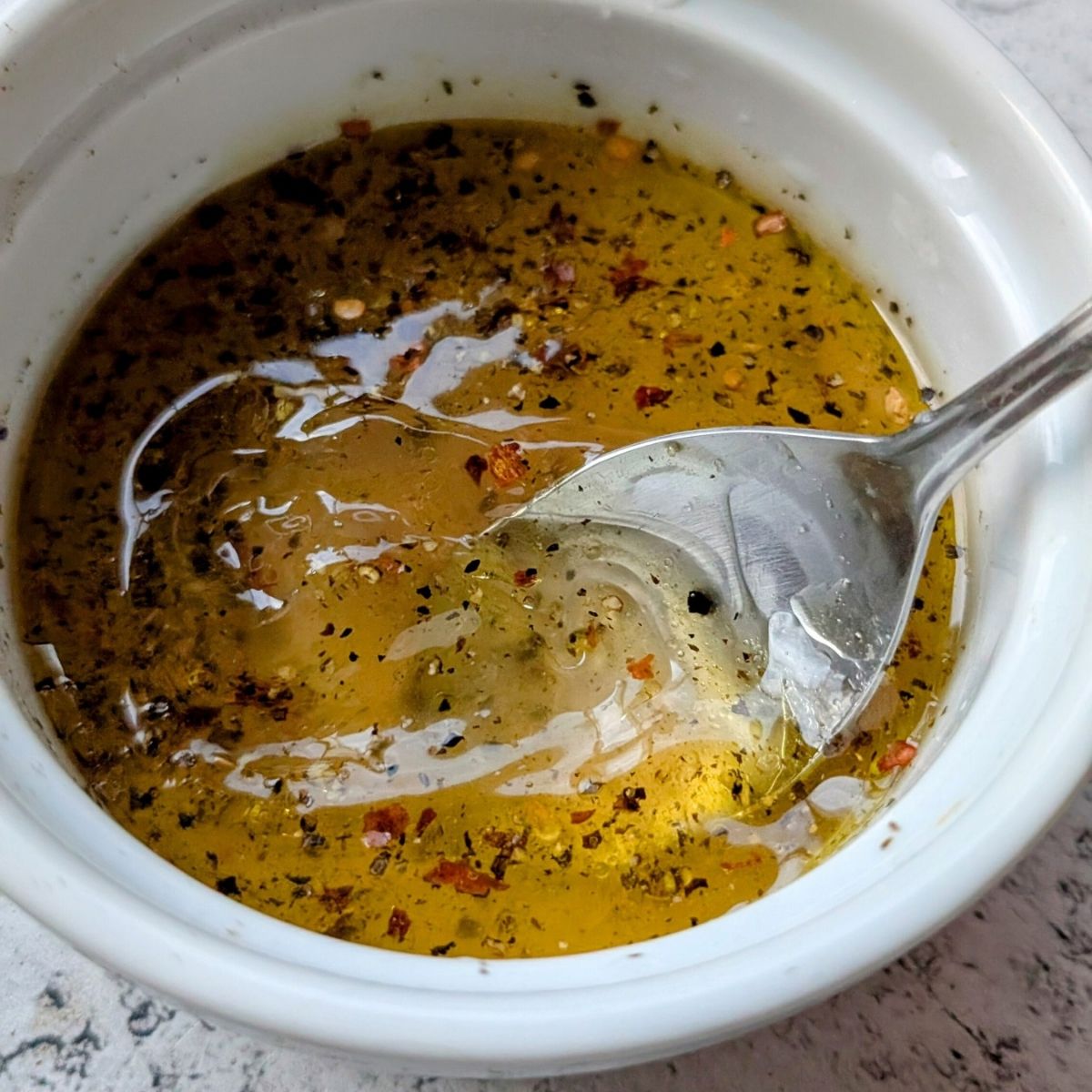lemon vinaigrette dressing in a bowl to make quinoa salad dressing with olive oil and chili flakes.