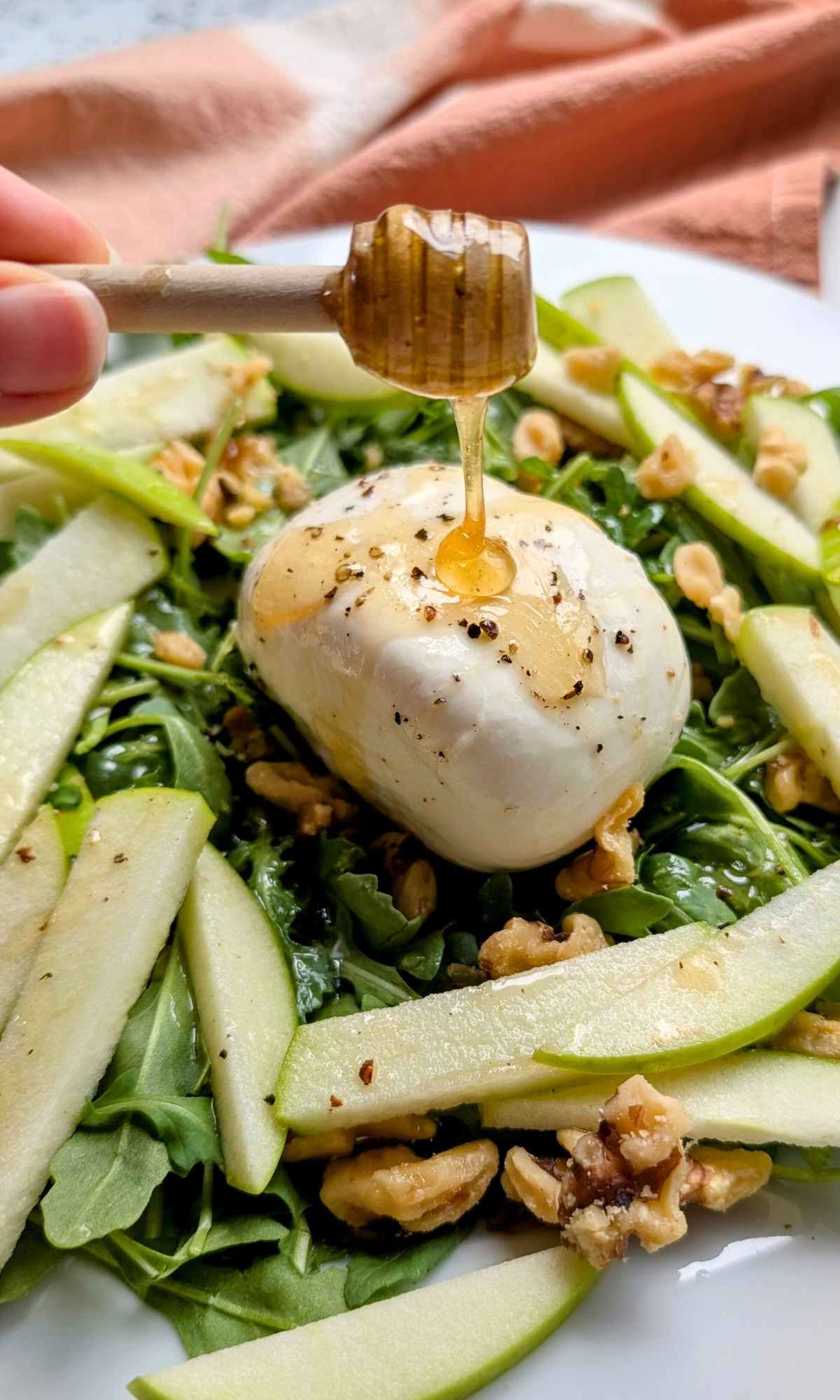 burrata with honey and apples on a bed of arugula greens with toasted walnuts.