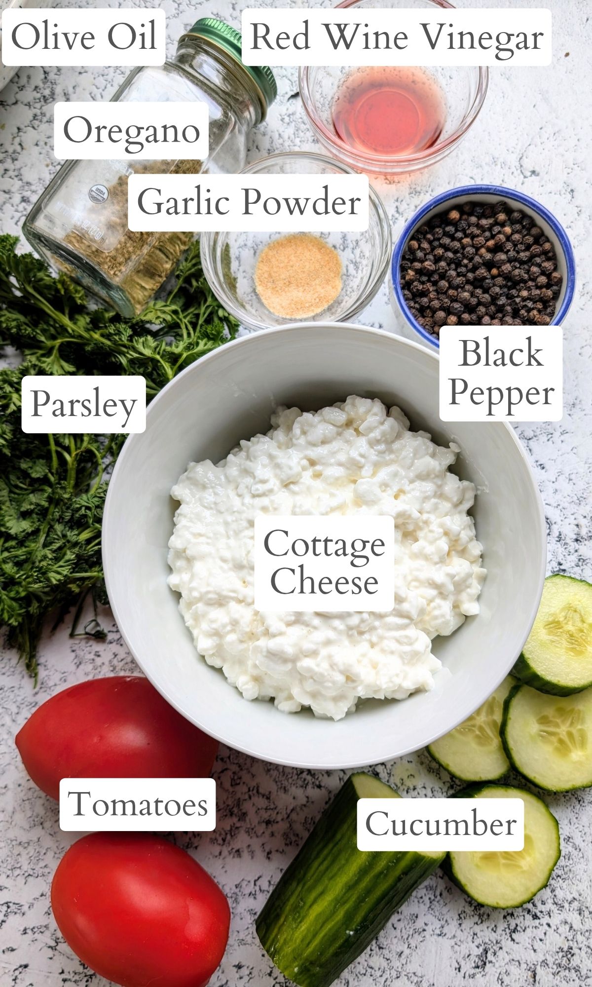 ingredients for cottage cheese salad with tomatoes, cucumber, and red wine vinegar dressing with herbs