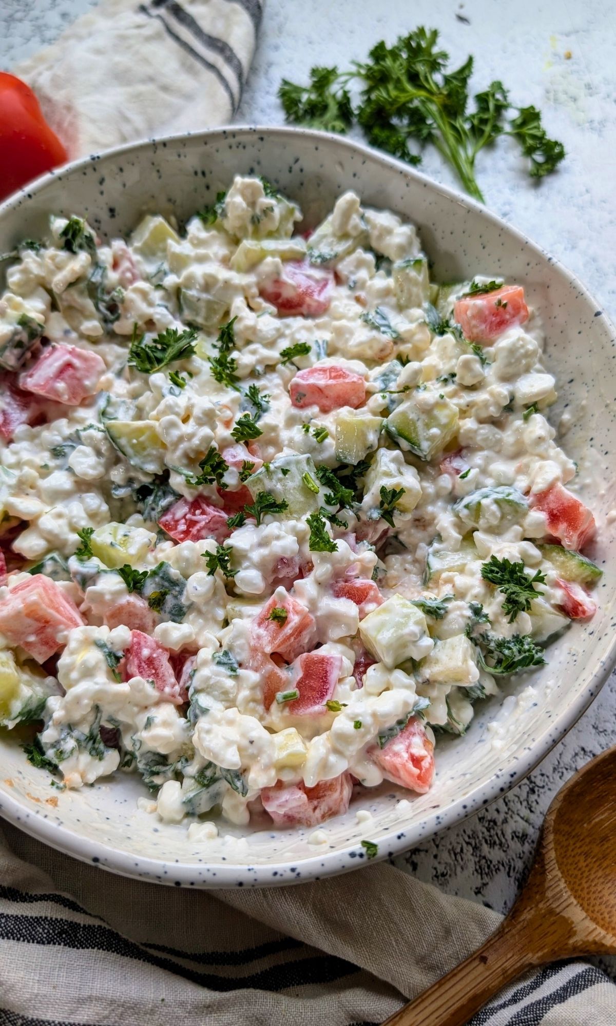 creamy cottage cheese salad with fresh chopped vegetables and parsley.