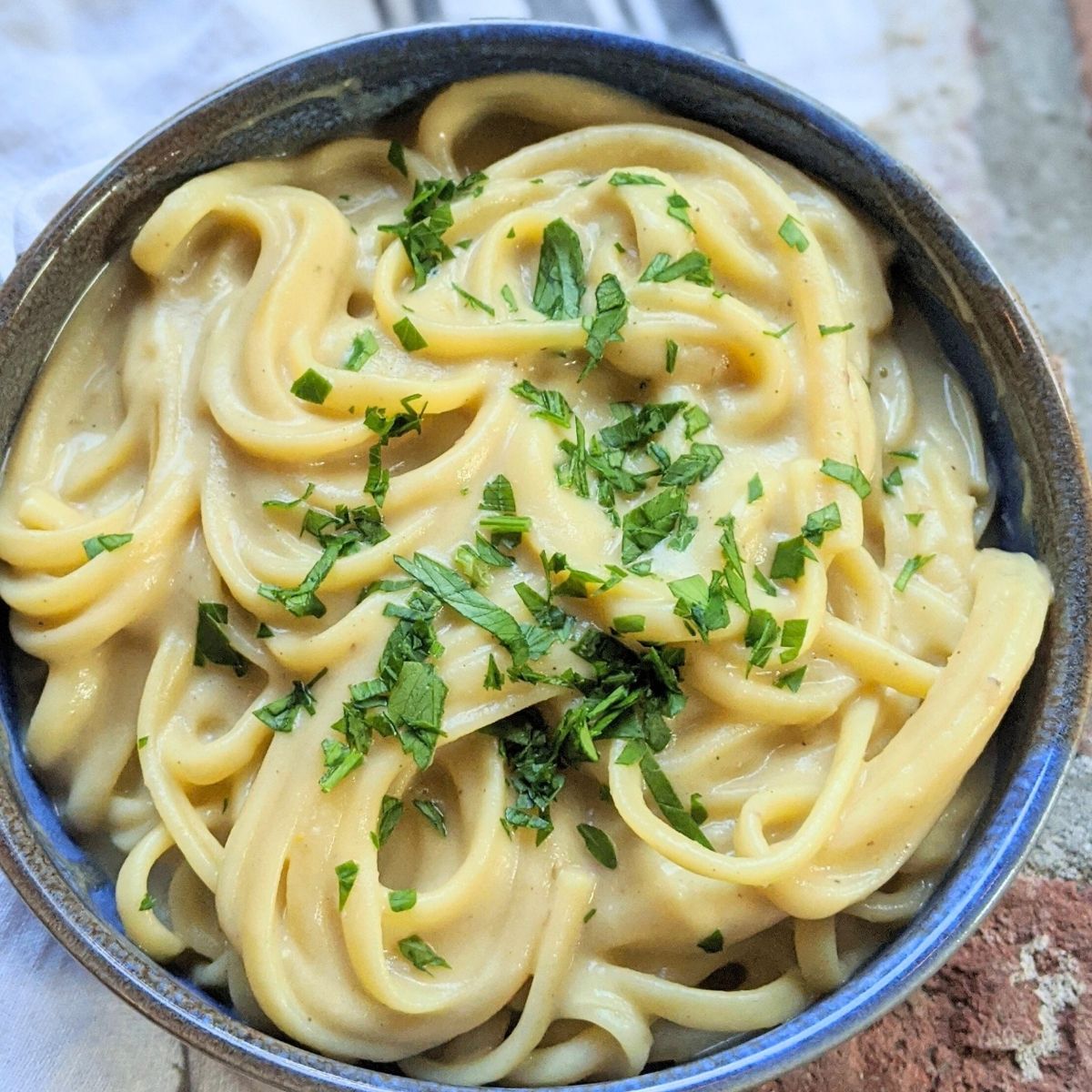 squash alfredo sauce poured into cooked fettuccini noodles for a tasty homemade zucchini pasta.