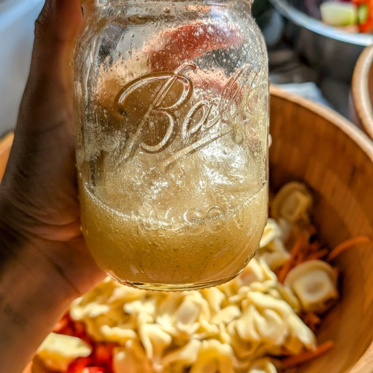 dressing for tortellini salad made with vinegar, sugar, olive oil, salt, and white pepper.