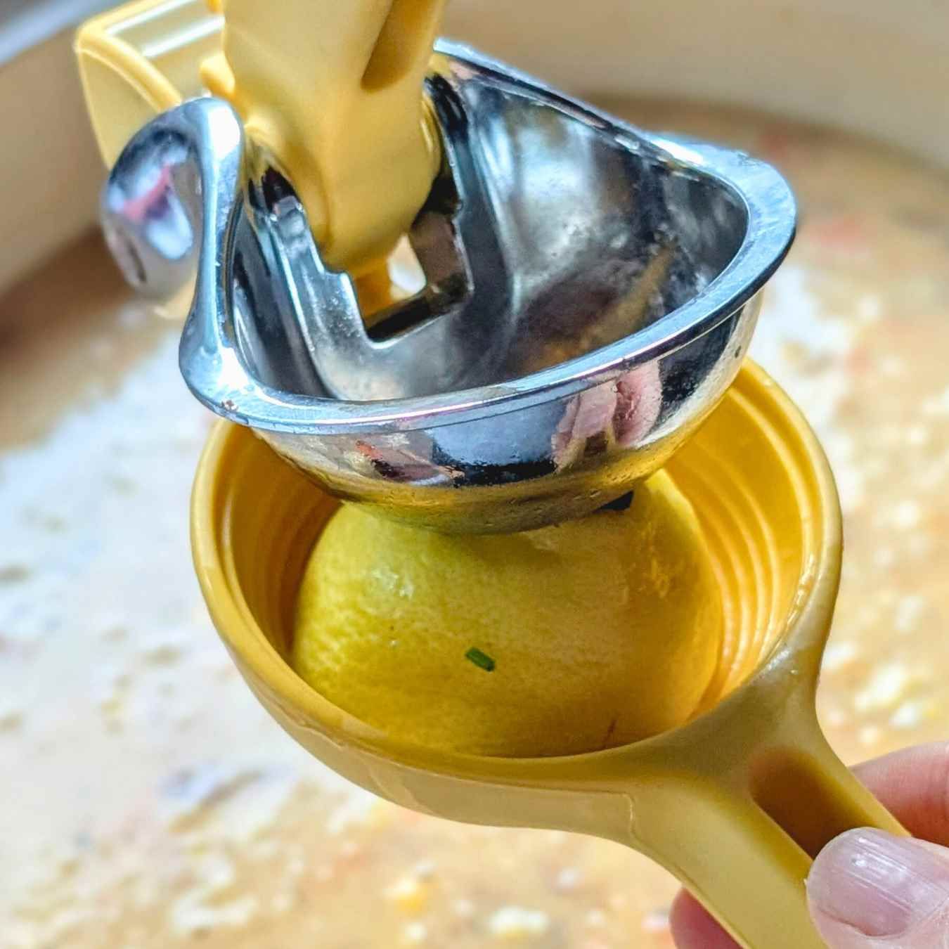 fresh lemon juice pressed in a hand-held lemon juicer into dairy free corn chowder.