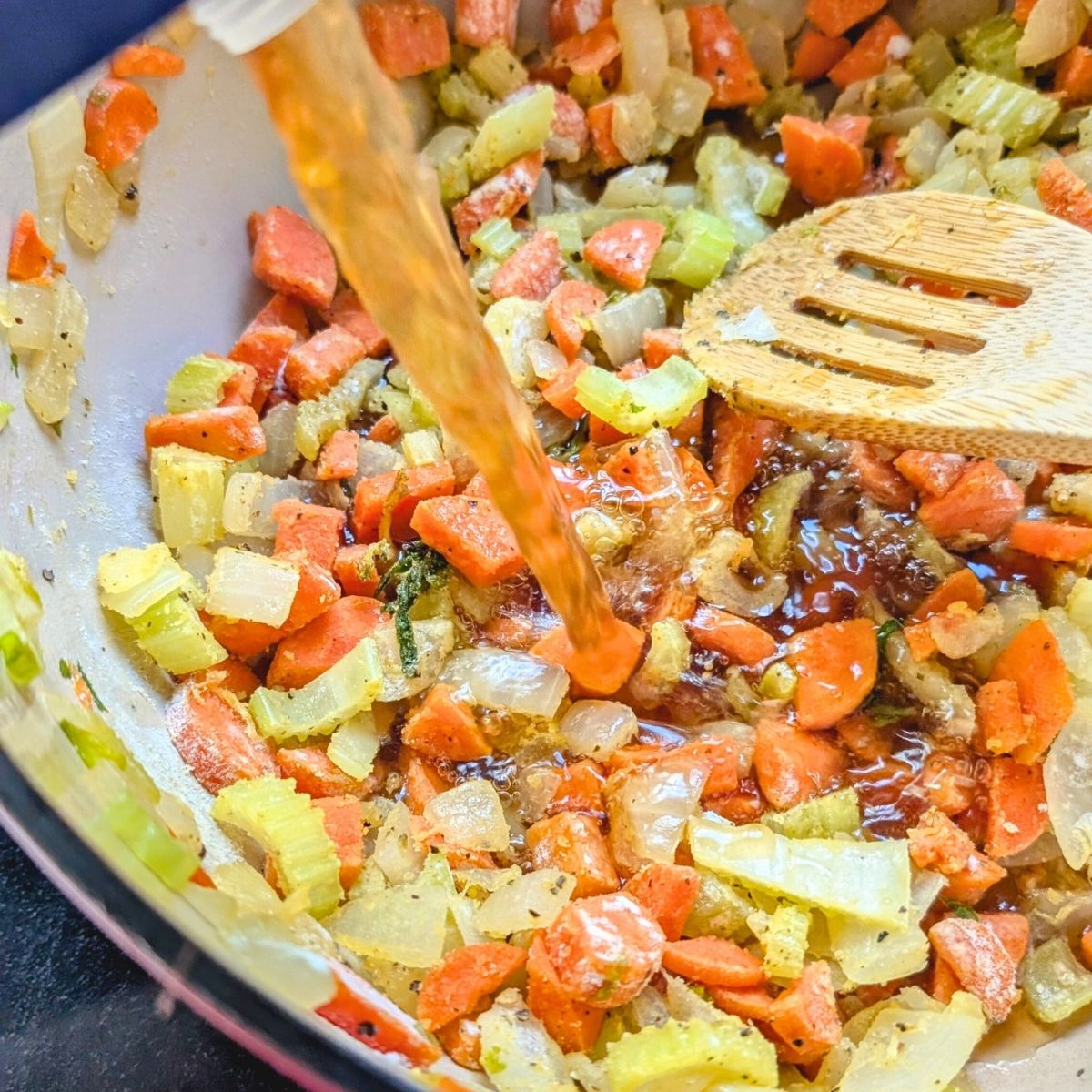 a pot with vegetable stock poured into veggies for a non dairy soup.