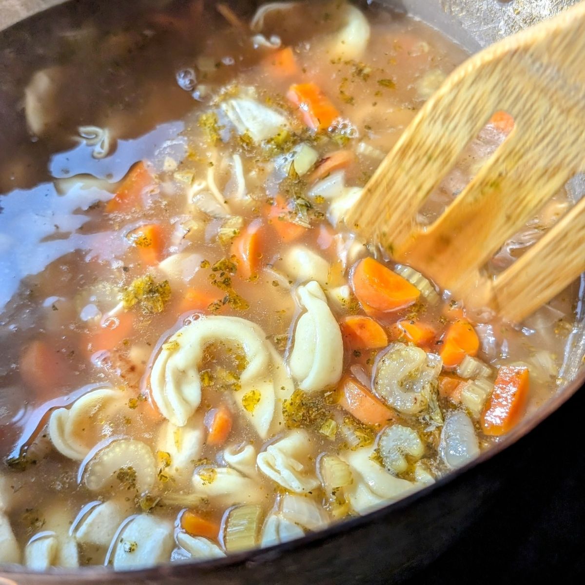 one pot tortellini soup with carrots and celery and onions in a pot