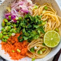 edamame noodle bowl recipe with carrots, green onions, lime, and cilantro