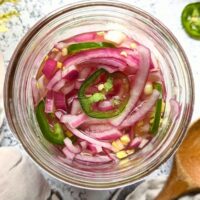 pickled red onions and jalapeno peppers in a jar with vinegar sugar and salt